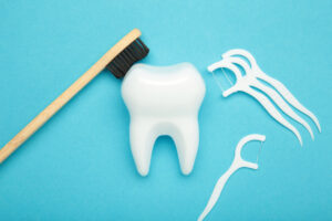 Dental floss and toothbrushes on blue background. Care of teeth health. Everyday routine teeth cleaning and flossing. Top view